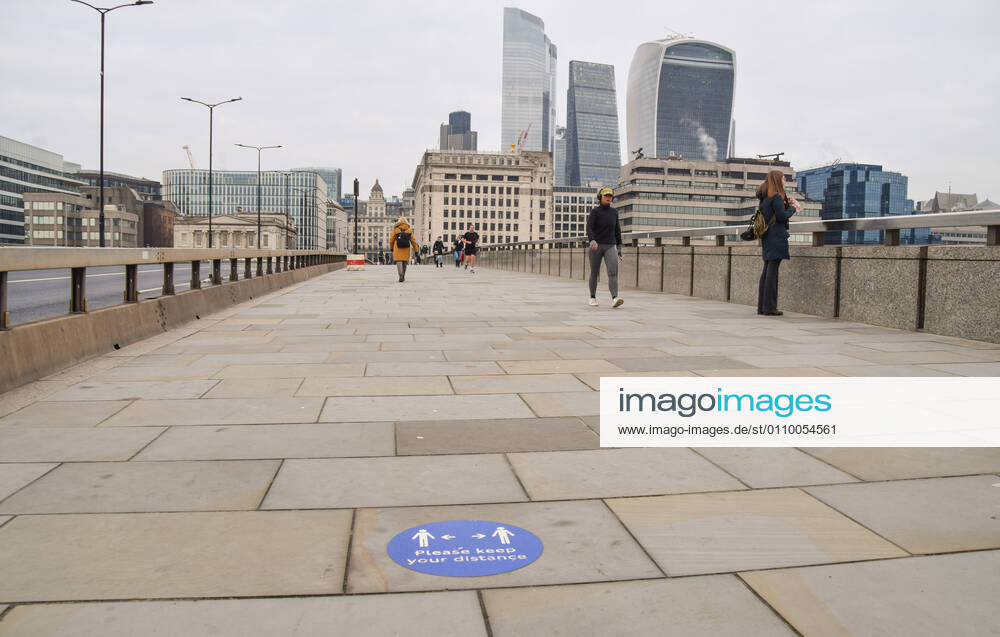 People walk past a social distancing sign on London Bridge..England remains under lockdown as the government battles to keep the coronavirus pandemic under control. London United Kingdom - ZUMAs197 20210115_zab_s197_004