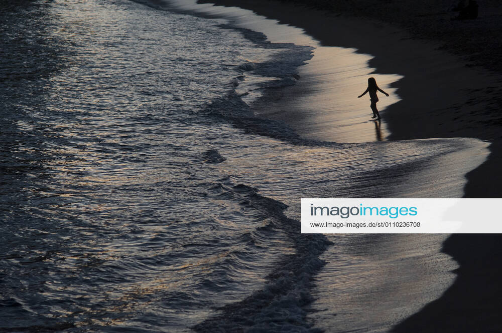 Despite winter temperatures, a child plays with the waves on the Nova Icaria beach in Barcelona at Sunday dusk. Imposed municipal lockdown to fight the spread of the coronavirus third wave in the Catalan region bans people leaving it s own city or town limits. Barcelona Spain - ZUMAb137 20210117_zap_b137_002