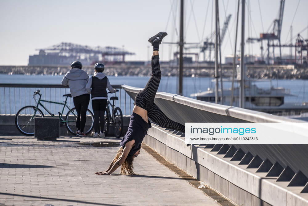 A woman in sportswear is seen stretching using a handrail in the Plaza de la Rosa de los Vientos..With public sports centers and gyms closed due to the increase in Covid-19 infections, many individual and social sports activity is taking place in public space such as open areas near the beaches. Barcelona Spain - ZUMAs197 20210117_zaa_s197_068