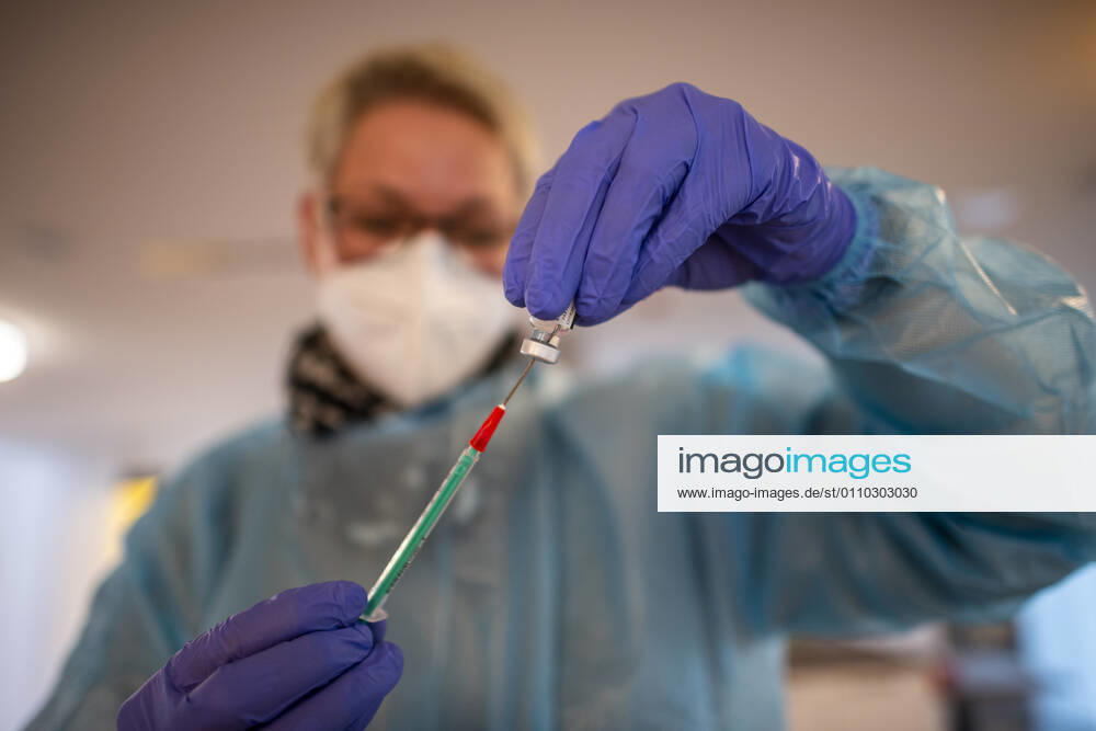 Corona vaccination in a home for the elderly A doctors assistant draws up a syringe with the Corona vaccine In a home for the elderly, the residents are vaccinated against an infection with the Corona virus Two vaccinations at intervals of 21 days are necessary to build up the vaccination protection with the mRNA vaccine from BioNTech Rietberg North Rhine Westphalia Germany