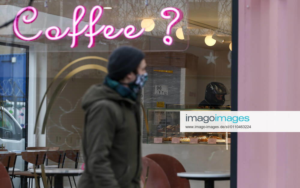 (210120) -- LONDON, Jan. 20, 2021 -- A man wearing a face mask walks past a cafe only open for takeaways in London, Britain, on Jan. 19, 2021. The number of people who have died within 28 days of a positive coronavirus test has surpassed the grim milestone of 90,000 in Britain after another 1,610 were confirmed, according to official figures released Tuesday. The latest daily death toll, the highest since the pandemic began in the country, brought the total number of coronavirus-related deaths in Britain to 91,470, the data showed. ) BRITAIN-LONDON-COVID-19-DEATH TOLL HanxYan