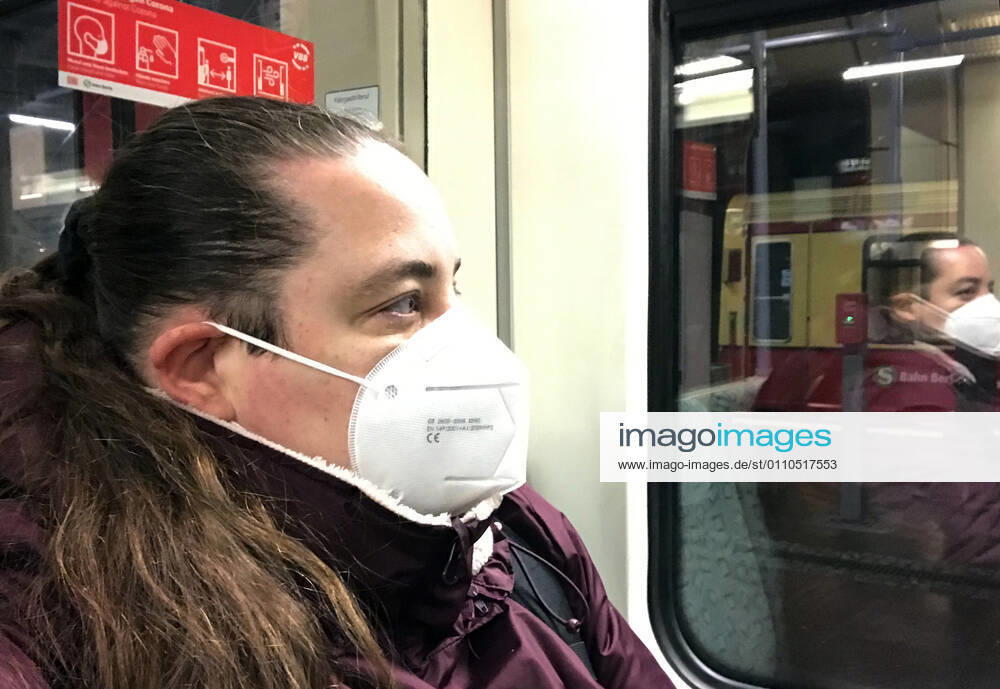 Berlin, GER - Frau in einer S-Bahn traegt in Zeiten der Coronapandemie eine FFP2-Maske. (MR=yes, 40-50 Jahre, Abteil, Alltag, Atemmaske, Bahn, Berlin, Coronaepidemie, Coronainfektion, Coronakrise, Coronapandemie, Coronavirus, Coronavirus SARS-CoV-2, Covid 19, Covid-19, deutsch, Deutschland, Europa, europaeisch, Fenster, FFP2, FFP2-Maske, Frau, geschuetzt, Gesellschaft, innen, Innenaufnahme, Jahreszeit, Kaukasierin, kaukasisch, Maske, Maskengebot, Maskenpflicht, Mensch, Mund-Nase-Schutz, Mund-Nasen-Schutz, Mundschutz, Mundschutzgebot, Mundschutzpflicht, Nahverkehr, oeffentlicher Personennahverkehr, OEPNV, Person, Personennahverkehr, QF, Querformat, Reflexion, S-Bahn, Schutz, Schutzmaske, spiegeln, Spiegelung, verpflichtend, Verpf