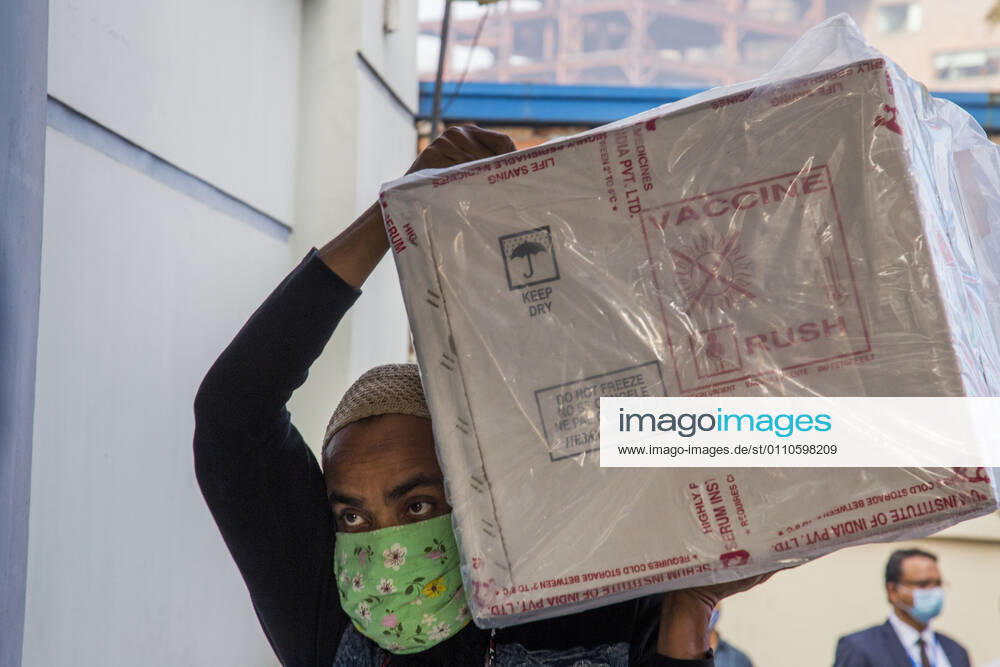 A worker carries a carton of Oxford-AstraZeneca COVID-19 vaccines that arrived from India to Bangladesh as a gift. Dhaka Bangladesh - ZUMAr331 20210121_zip_r331_001