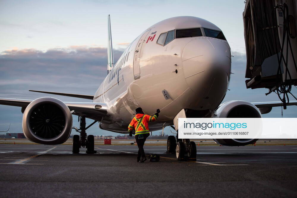 A ground worker approaches a WestJet Airlines Boeing 737 Max aircraft after it arrived at Vancouver International Airport in Richmond, B.C., on Thursday, January 21, 2021. The flight from Calgary is the first commercial Boeing 737 Max flight in Canada since the aircraft was grounded worldwide in 2019 following two deadly crashes. Transport Canada lifted its grounding order for the Max on Wednesday after approving design changes to the plane and requiring pilots to undergo additional training. Richmond Canada - ZUMAc35_ 20210121_zaf_c35_021
