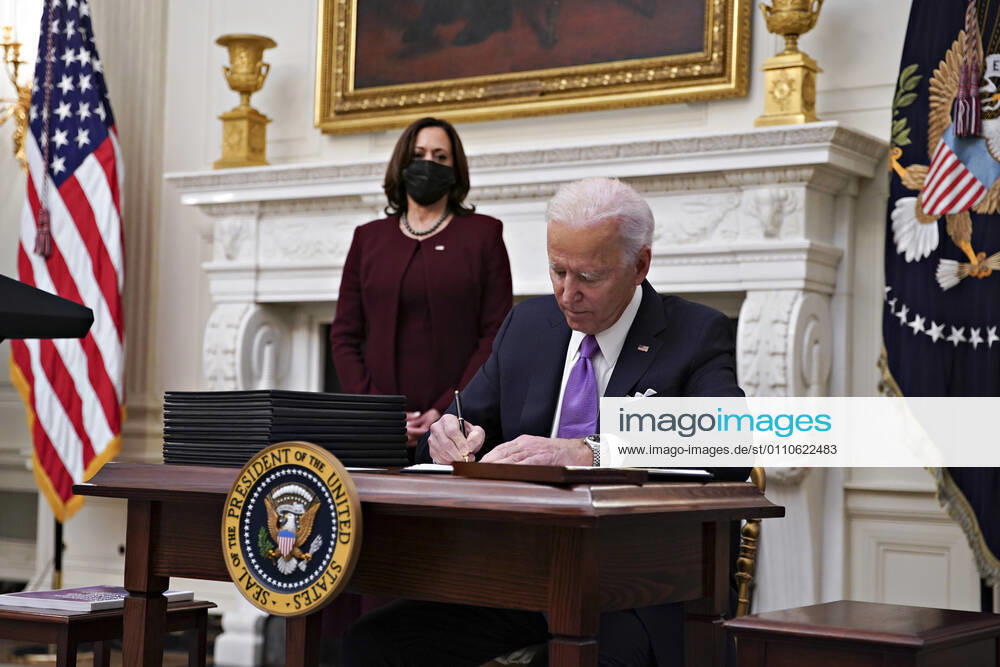 U.S. President Joe Biden signs an executive order after speaking during an event on his administration s Covid-19 response with U.S. Vice President Kamala Harris, left, in the State Dining Room of the White House in Washington, D.C., U.S., on Thursday, Jan. 21, 2021. Biden in his first full day in office plans to issue a sweeping set of executive orders to tackle the raging Covid-19 pandemic that will rapidly reverse or refashion many of his predecessor s most heavily criticized policies Washington USA - ZUMAs152 20210121_zaa_s152_116