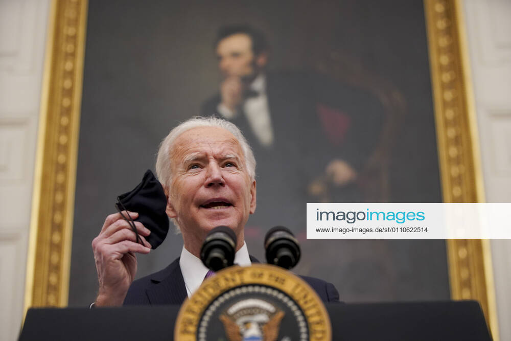 U.S. President Joe Biden holds a protective mask while speaking during an event on his administration s Covid-19 response in the State Dining Room of the White House in Washington, D.C., U.S., on Thursday, Jan. 21, 2021. Biden in his first full day in office plans to issue a sweeping set of executive orders to tackle the raging Covid-19 pandemic that will rapidly reverse or refashion many of his predecessor s most heavily criticized policies Washington USA - ZUMAs152 20210121_zaa_s152_121