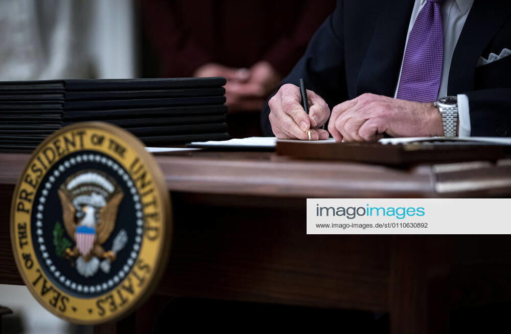 U.S. President Joe Biden signs an executive order after speaking during an event on his administration s Covid-19 response in the State Dining Roomof the White House in Washington, D.C., U.S., on Thursday, Jan. 21, 2021. Biden in his first full day in office plans to issue a sweeping set of executive orders to tackle the raging Covid-19 pandemic that will rapidly reverse or refashion many of his predecessor s most heavily criticized policies. WAXP20210121123 AlxDrago