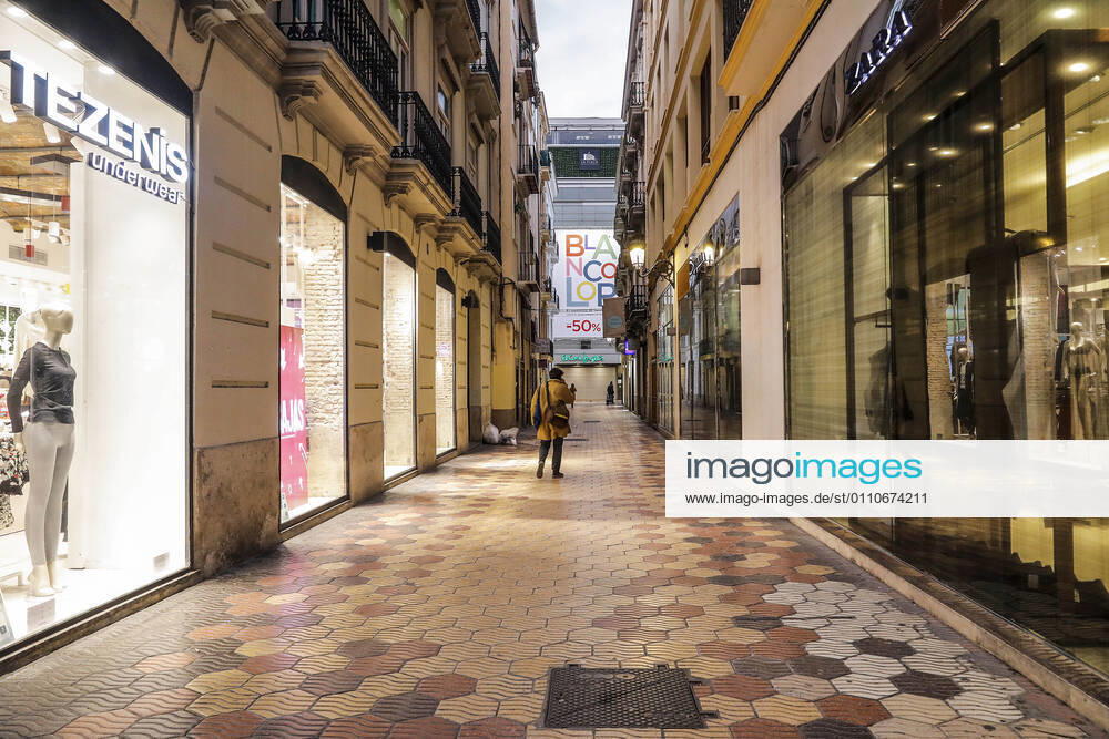 A shopping street in Valencia with all its establishments closed on the first day of the total closure of the hotel and catering industry and shops at 6pm in Valencia, Comunidad Valenciana (Spain), on 21 January 2021. At 0.00 am today, the decree of the Valencian Government came into force by which the region s hotel industry and shops were totally closed at 6.00 pm, except for food, pharmacy and other essential shops, as well as gyms and other sports facilities. These restrictions will remain in force for 14 days, until 4 February. 21 JANUARY 2021;SHOPS;RESTRICTIONS;HOSPITALITY;RESTAURANTS;PERIMETER CLOSURE;VIRUS;CORONAVIRUS;PANDEMIC;INFECTED Rober Solsona LagenciaEP 01 21 2021 VALENCIA (VALENCIA) VALENCIA (VALENCIA) Spain