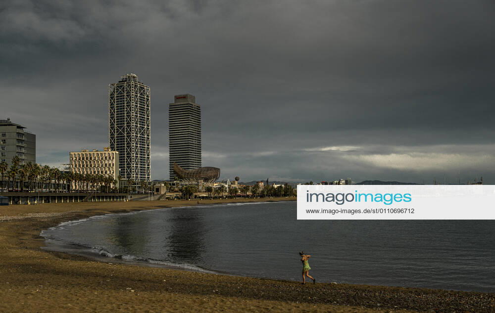 A commuter leaves the water after swimming at Barcelona s nearly deserted beach after a rainy storm. Barcelona Spain - ZUMAo105 20210122_zap_o105_005