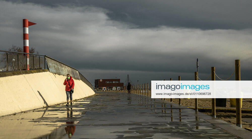 A commuter walks at Barcelona s nearly deserted beach after a rainy storm. Barcelona Spain - ZUMAo105 20210122_zap_o105_006