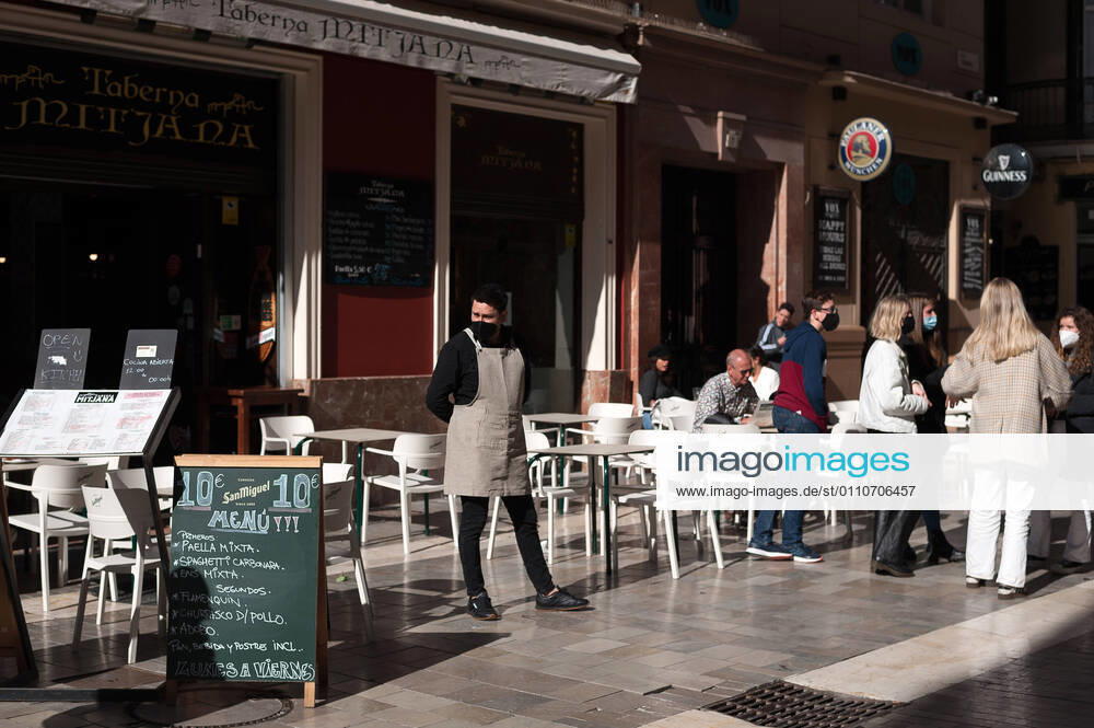 An employee seen waiting for customers outside Mitjana bar at Caldereria street amid coronavirus pandemic..The region of Andausia suffers an uncontrolled daily rise of coronavirus cases, despite of hard restrictions imposed in the daily life. During the last weeks, Andalusia has reported thousands of infections everyday in the region while the hospital pressure continue rising. Malaga Spain - ZUMAs197 20210122_zaa_s197_042