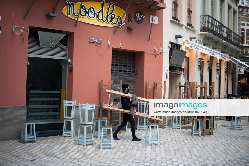 A waiter seen carrying a group of chairs outside noodles restaurant during the mandatory closure..The third wave of coronavirus disease has impacted most daily income in the Andalusia region after the Christmas holidays. Following the increase of infections, several regional governments decided to take new measures such as limiting mobility perimeters between cities and towns and closing hospitality and commercial sectors in the afternoon. Malaga Spain - ZUMAs197 20210122_zaa_s197_074