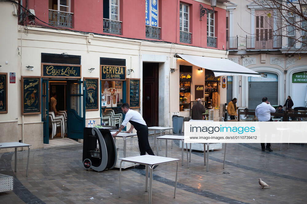 A waiter seen carrying a table outside Casa Lola restaurant during the mandatory closure..The third wave of coronavirus disease has impacted most daily income in the Andalusia region after the Christmas holidays. Following the increase of infections, several regional governments decided to take new measures such as limiting mobility perimeters between cities and towns and closing hospitality and commercial sectors in the afternoon. Malaga Spain - ZUMAs197 20210122_zaa_s197_077