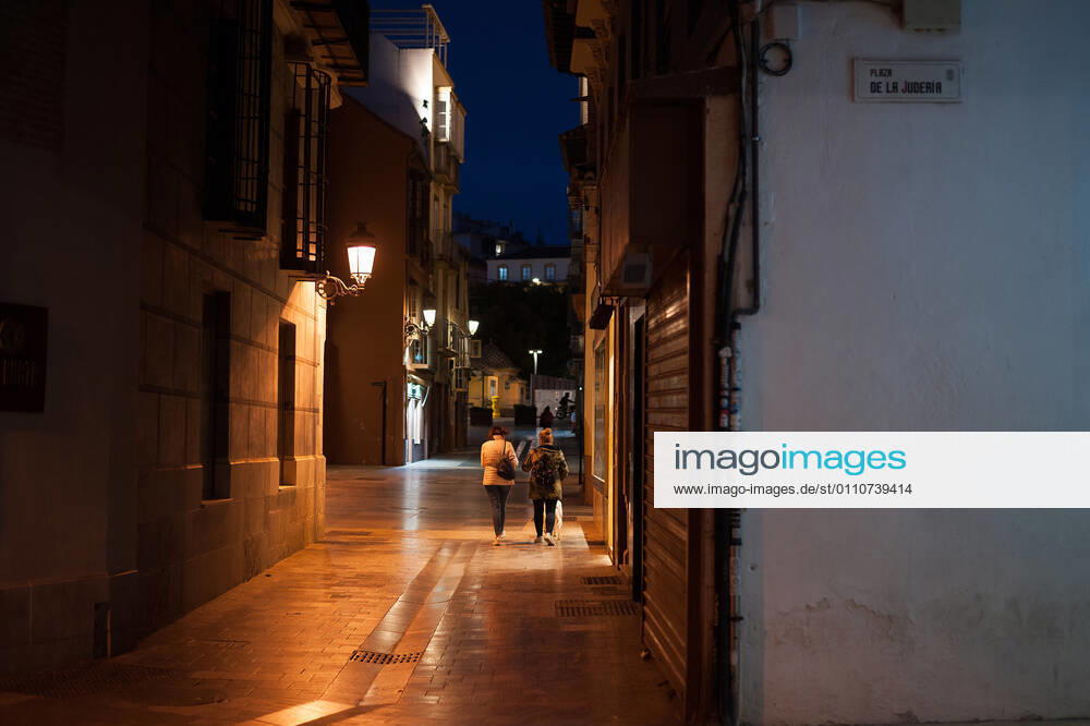 A couple walking at Granada street during the mandatory closure..The third wave of coronavirus disease has impacted most daily income in the Andalusia region after the Christmas holidays. Following the increase of infections, several regional governments decided to take new measures such as limiting mobility perimeters between cities and towns and closing hospitality and commercial sectors in the afternoon. Malaga Spain - ZUMAs197 20210122_zaa_s197_078