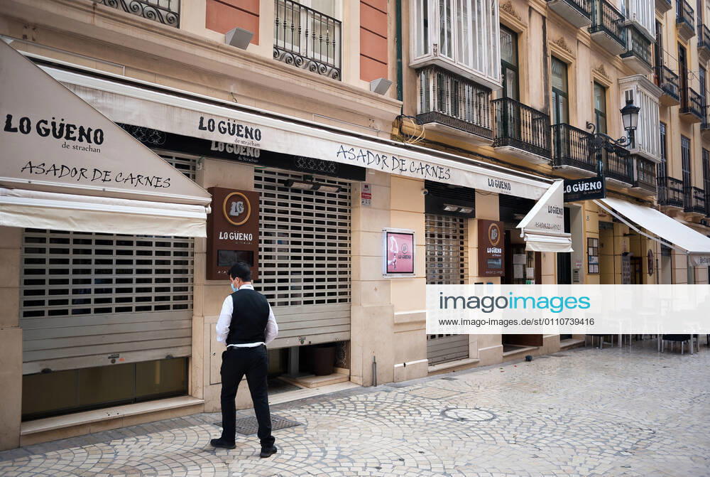 An employee seen closing Lo Gueno restaurant at Strachan street during the mandatory closure..The third wave of coronavirus disease has impacted most daily income in the Andalusia region after the Christmas holidays. Following the increase of infections, several regional governments decided to take new measures such as limiting mobility perimeters between cities and towns and closing hospitality and commercial sectors in the afternoon. Malaga Spain - ZUMAs197 20210122_zaa_s197_079