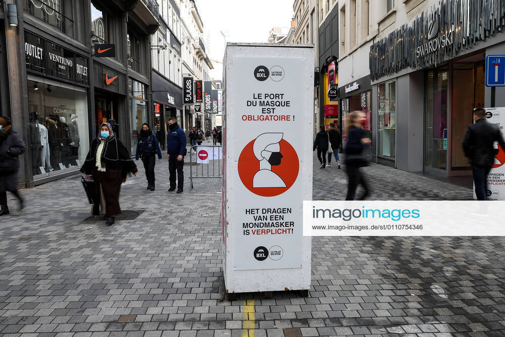 (210123) -- BRUSSELS, Jan. 23, 2021 -- People walk past a sign reminding people to wear face masks on a shopping street in Brussels, Belgium, Jan. 22, 2021. The annual Belgian winter sales kicked off on Jan. 4. To boost consumption, the scheduled four-week-long winter sales have been extended by two weeks until Feb. 15. ) BELGIUM-BRUSSELS-COVID-19-WINTER SALES ZhangxCheng