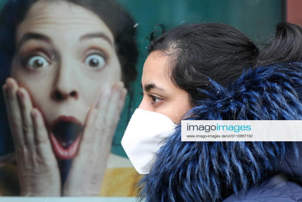 Winter wetter mit Schnee , Frau mit Safety Mask FFP2 und eine Werbung during the Hard Lockdown of the Covid 19 Coronavirus Pandemie in Nuremberg Nurnberg , Bayern , Deutschland . January 24 , 2021.