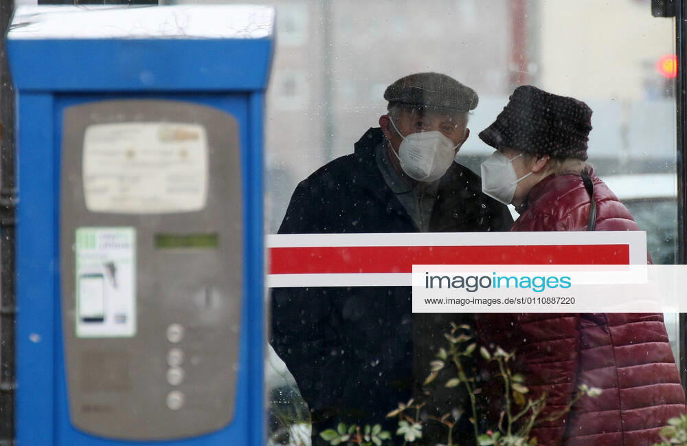 Winter wetter mit Schnee , older couple with Safety Mask FFP2 are seen at Bus Stop during the Hard Lockdown of the Covid 19 Coronavirus Pandemie in Nuremberg Nurnberg , Bayern , Deutschland . January 24 , 2021.