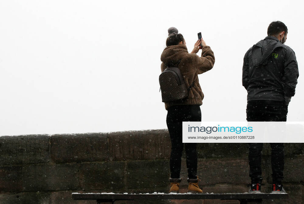 Winter wetter mit Schnee , two people take photos of the snow during the Hard Lockdown of the Covid 19 Coronavirus Pandemie in Nuremberg Nurnberg , Bayern , Deutschland . January 24 , 2021.