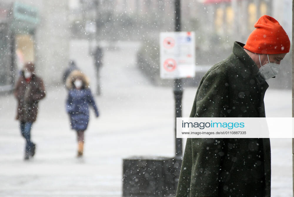 Winter wetter mit Schnee , a men with Safety mask FFP2 is seen under the snow during the Hard Lockdown of the Covid 19 Coronavirus Pandemie in Nuremberg Nurnberg , Bayern , Deutschland . January 24 , 2021.