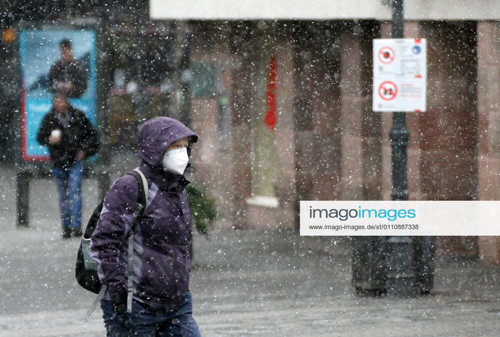 Winter wetter mit Schnee , a women with Safety mask FFP2 is seen under the snow during the Hard Lockdown of the Covid 19 Coronavirus Pandemie in Nuremberg Nurnberg , Bayern , Deutschland . January 24 , 2021.