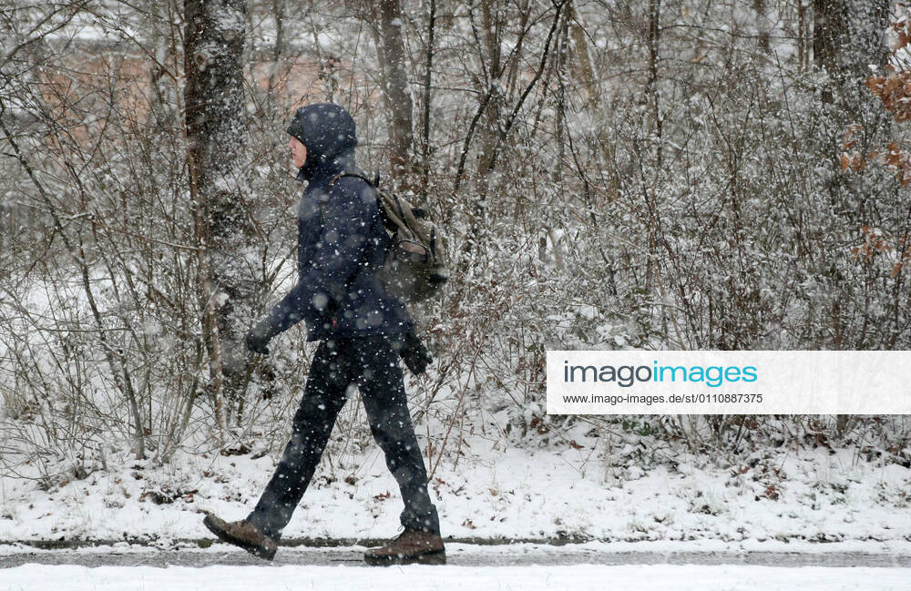 Winter wetter mit Schnee , a men walks under the snow during the Hard Lockdown of the Covid 19 Coronavirus Pandemie in Nuremberg Nurnberg , Bayern , Deutschland . January 24 , 2021.