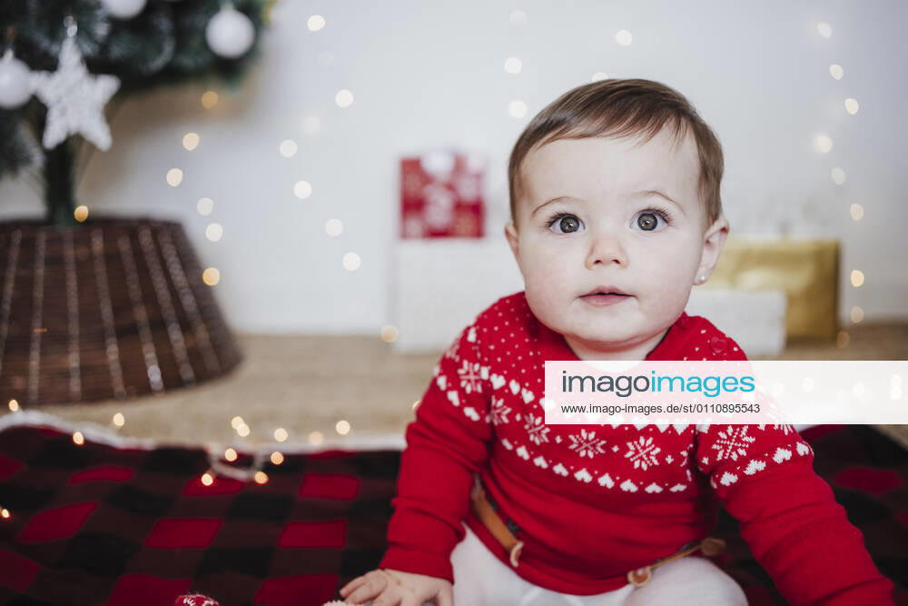 Cute baby girl staring while sitting at home during Christmas model released Symbolfoto property released EBBF01939