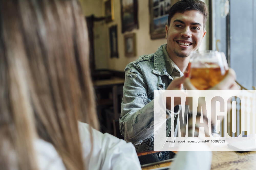 IMAGO Creative: Landleben - Essen Happy friends smiling while toasting drinks in bar model released Symbolfoto property released EGAF01286