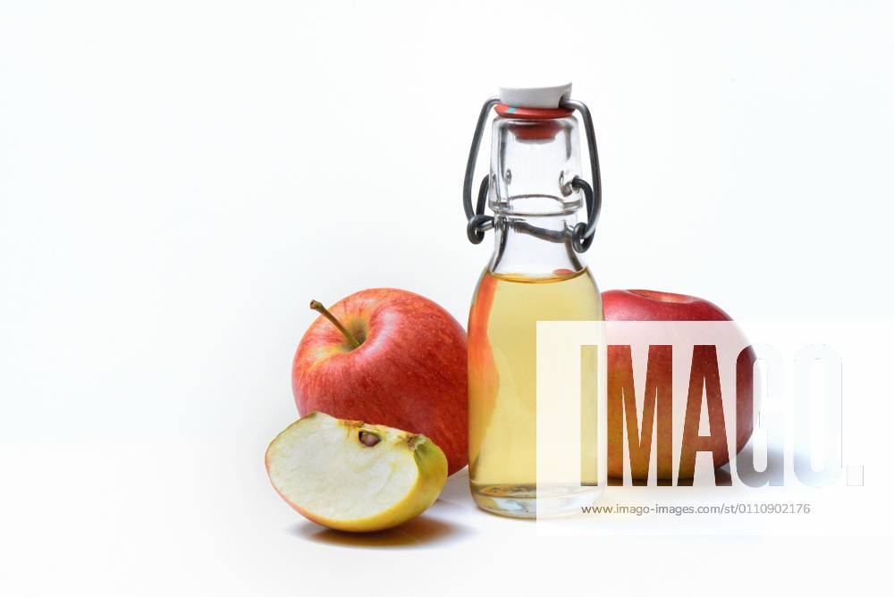 Bottle with apple cider vinegar and apples