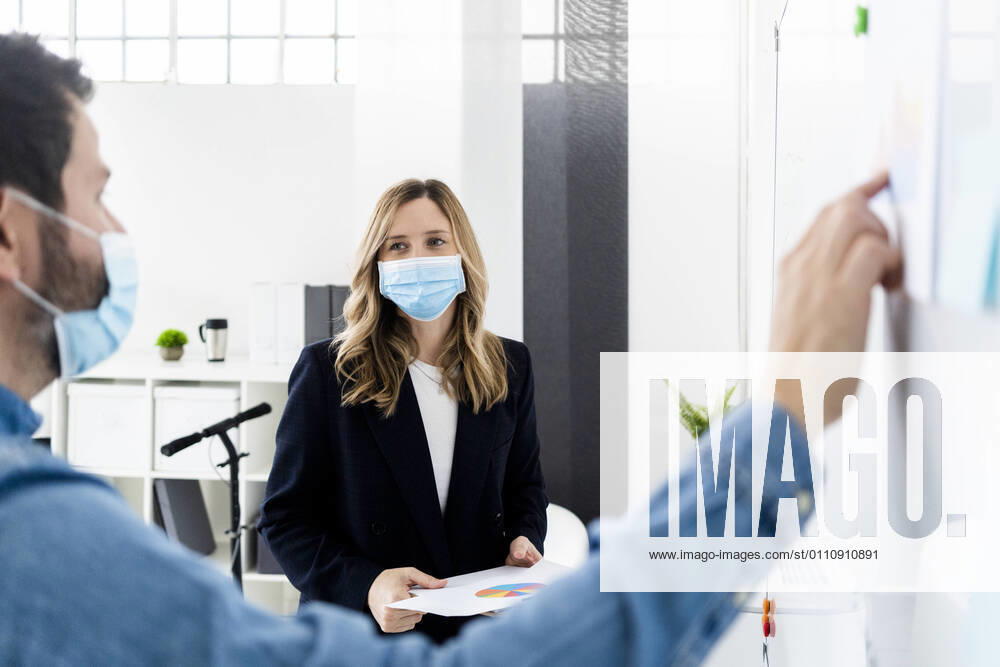 IMAGO Creative: 2022 Aussichten Business people wearing protective masks working in office model released Symbolfoto property released GIOF10443