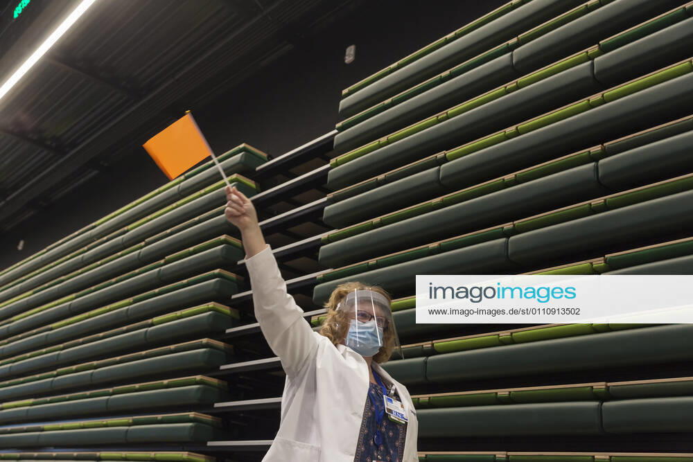 Seattle, Washington, U.S: SHARON WATTS, a nurse manager with with Virginia Mason, waves a flag to notify the next patient at a pop up COVID-19 vaccine clinic at the Amazon Headquarters in Seattle on Sunday, January 24, 2021. Amazon partnered with Virginia Mason Franciscan Health to vaccinate 2,000 Washingtonians who currently qualify to be vaccinated under the stateÃ¢â‚¬â ¢s COVID-19 Vaccine Phases guidelines. Seattle U.S. - ZUMAg235 20210124_zap_g235_004