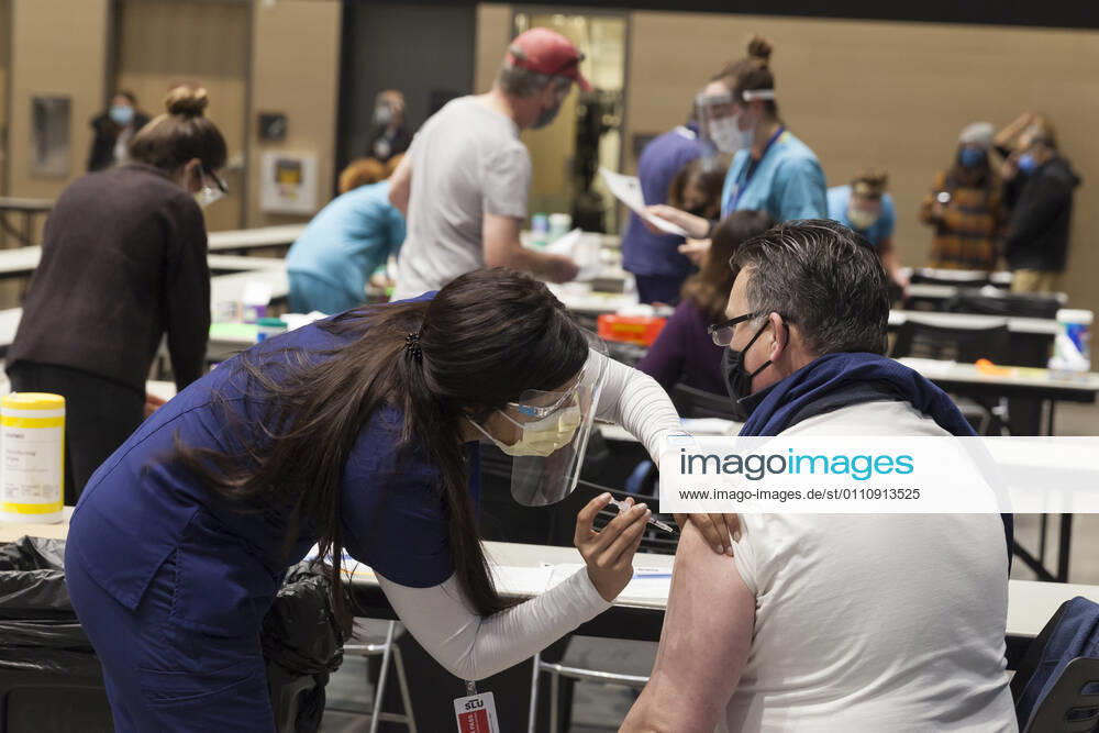 Seattle, Washington, U.S: MARYAM MALLICK with Virginia Mason gives an injection to a patient at a pop up COVID-19 vaccine clinic at the Amazon Headquarters in Seattle on Sunday, January 24, 2021. Amazon partnered with Virginia Mason Franciscan Health to vaccinate 2,000 Washingtonians who currently qualify to be vaccinated under the stateÃ¢â‚¬â ¢s COVID-19 Vaccine Phases guidelines. Seattle U.S. - ZUMAg235 20210124_zap_g235_005