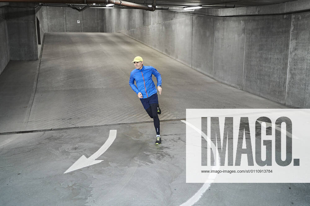 Mature man running in parking garage of residential building model released Symbolfoto property released JAHF00084