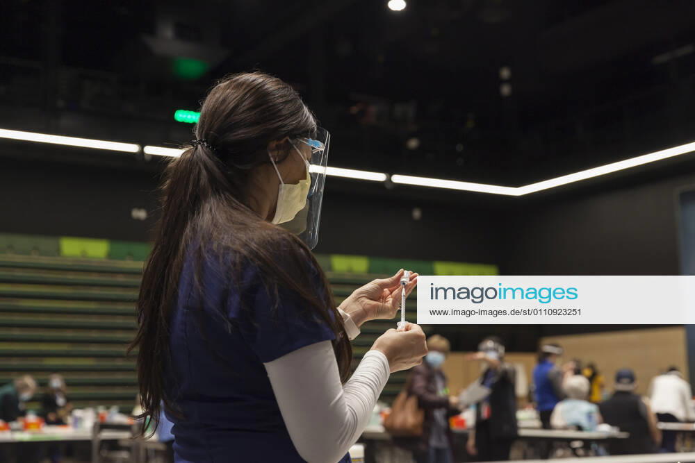 MARYAM MALLICK with Virginia Mason prepares to give an injection to a patient at a pop up COVID-19 vaccine clinic at the Amazon Headquarters in Seattle on Sunday, January 24, 2021. Amazon partnered with Virginia Mason Franciscan Health to vaccinate 2,000 Washingtonians who currently qualify to be vaccinated under the stateâ€⠢s COVID-19 Vaccine Phases guidelines. Seattle USA - ZUMAg235 20210124_zap_g235_017