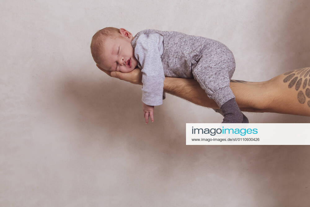 Father s hand carrying son in arm against white background at studio model released Symbolfoto NGF00731