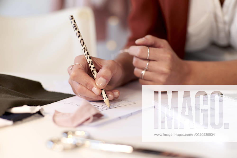 Female fashion professional drawing design on paper at desk in atelier model released Symbolfoto property released VEGF03422