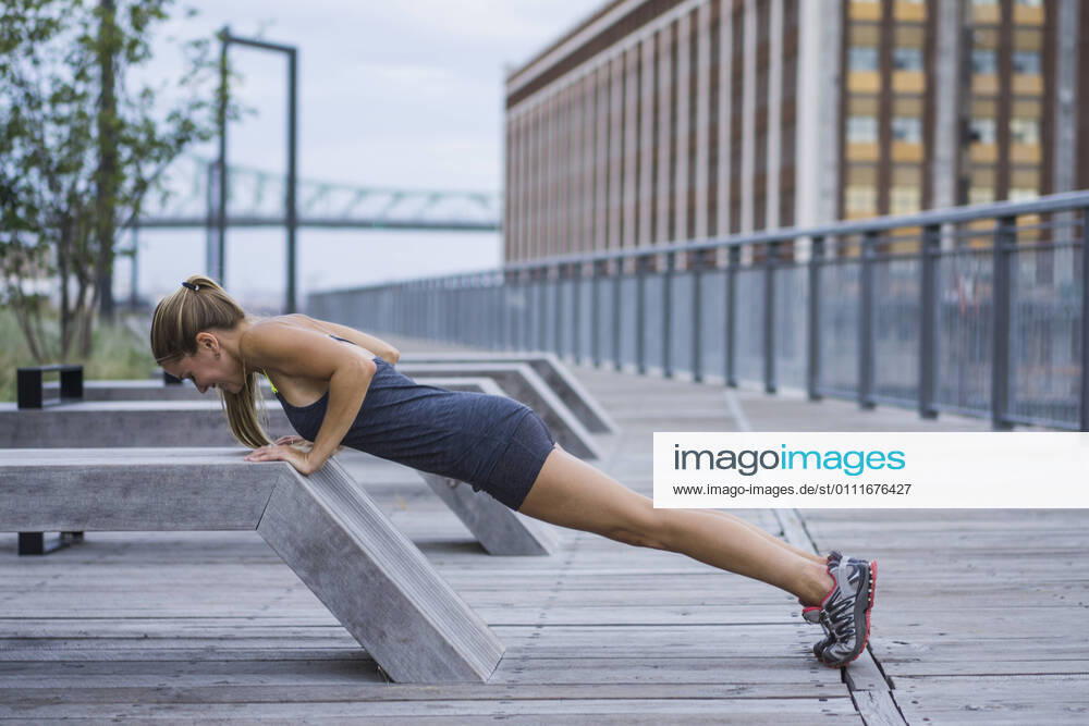 Athletic woman stretching on urban boardwalk Montreal, QC, Canada CR_CHPH210119C-613794-01 ,model released, Symbolfoto