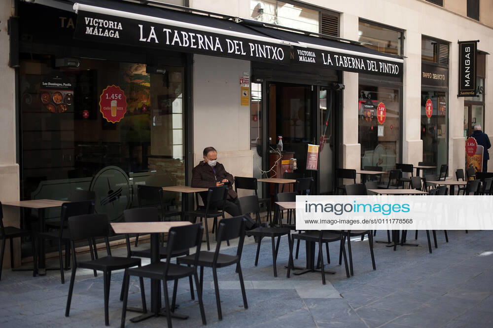 A costumer sitting at an empty terrace outside La terraza del Pintxo bar during the closure of the hospitality sector and non-essential activities as part of a partial lockdown..For two weeks, besides the limit on mobility between cities, many municipalities and Costa del Sol districts (including the Malaga capital) will have to close bars, restaurants and stores as measures to curb the spread of the coronavirus pandemic. In the lead of Andalusia, Malaga is the city with more daily coronavirus infections and a high rate of hospitalizations. Malaga Spain - ZUMAs197 20210202_zab_s197_009