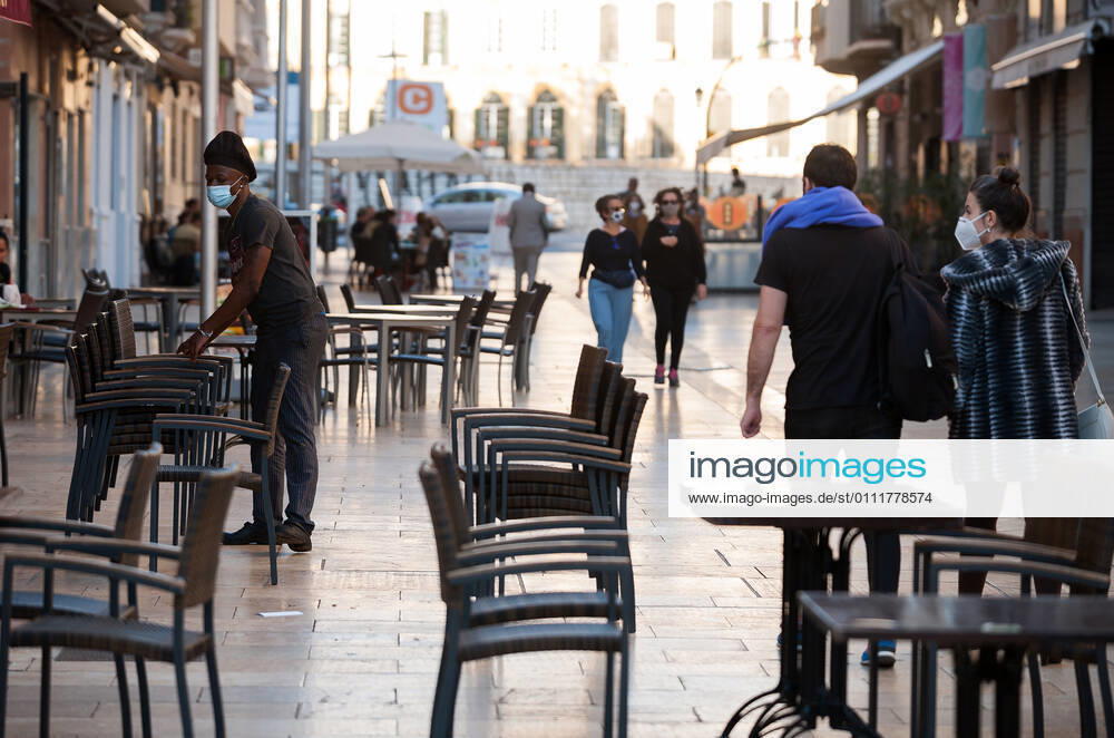A worker stacking up chairs outside the empty La plaza Malaga restaurant terrace during the closure of the hospitality sector and non-essential activities as part of a partial lockdown..For two weeks, besides the limit on mobility between cities, many municipalities and Costa del Sol districts (including the Malaga capital) will have to close bars, restaurants and stores as measures to curb the spread of the coronavirus pandemic. In the lead of Andalusia, Malaga is the city with more daily coronavirus infections and a high rate of hospitalizations. Malaga Spain - ZUMAs197 20210202_zab_s197_015