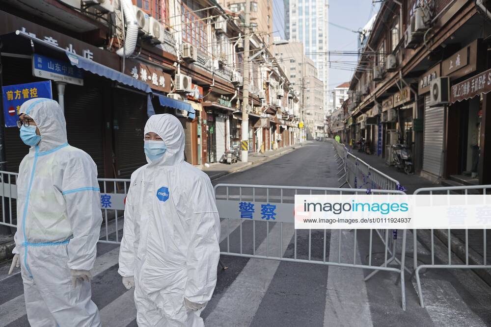 Police officers wearing personal protective equipment (PPE) stand guard at a residential community under lockdown at Huangpu District on February 4, 2021 in Shanghai, China.