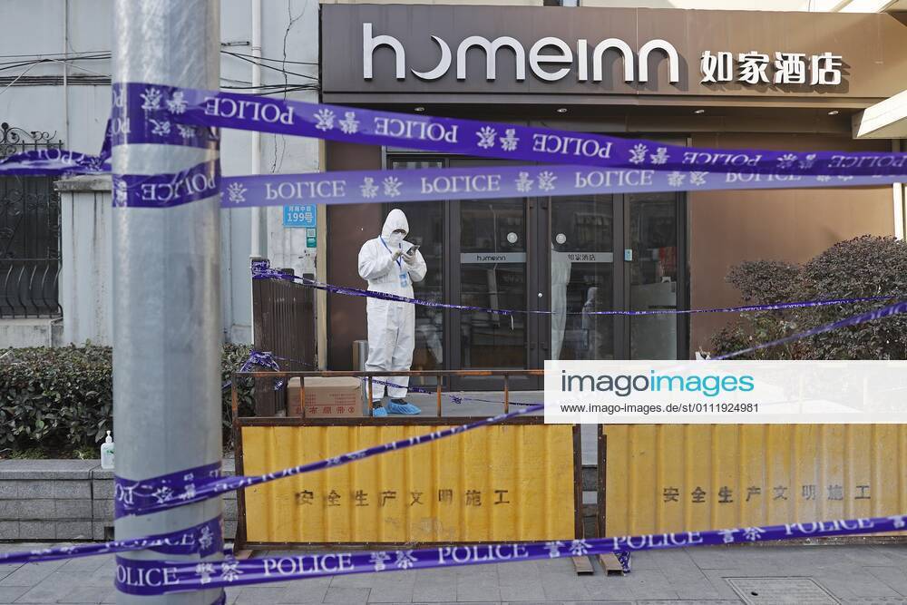 A police officer wearing personal protective equipment (PPE) stands guard at a residential community under lockdown at Huangpu District on February 4, 2021 in Shanghai, China.