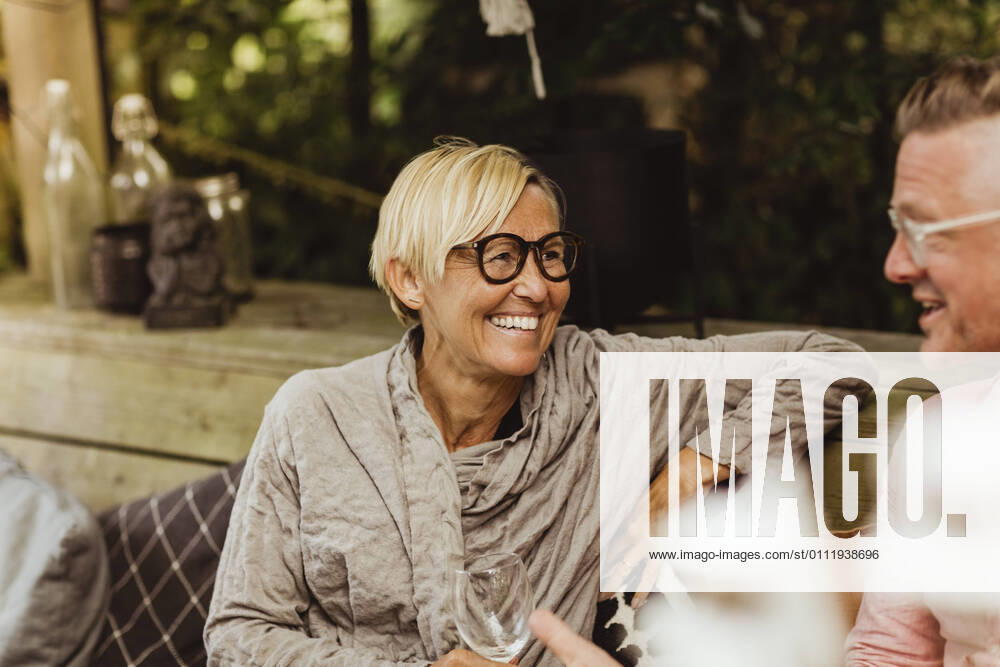 IMAGO Creative: Landleben - Essen Smiling grandmother looking at father while sitting in back yard Sweden, Gothenburg, model released, property released