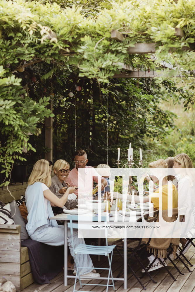 IMAGO Creative: Landleben - Essen Happy family having meal at garden party Sweden, Gothenburg, model released, property released