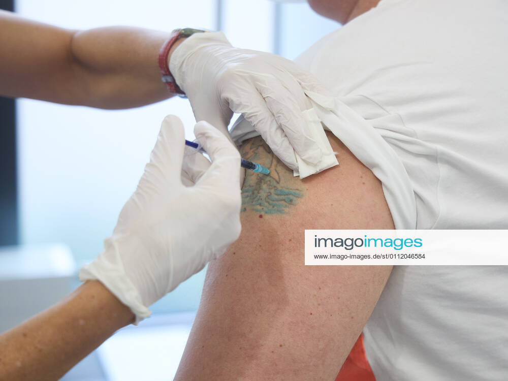 Vaccination of a middle-aged man, vaccination takes place in an unstained spot in a tattoo, Bavarian Vaccination Center Augsburg, press tour Bavarian Vaccination Center Augsburg, press tour
