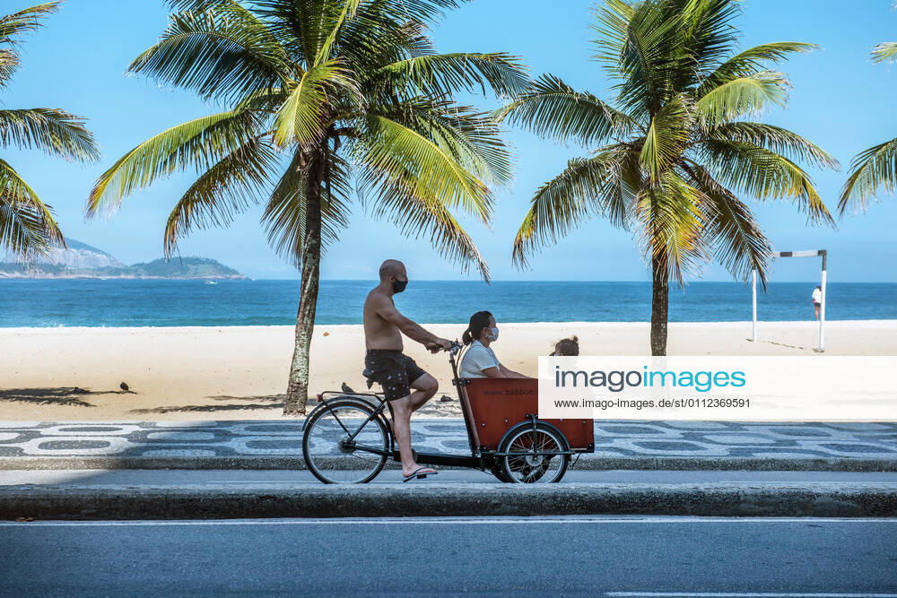 Brazil under COVID-19 RIO DE JANEIRO, BRAZIL, APR 29: COVID 19 - family wearing masks rides a bicycle during a corona virus pandemic at Ipanema Beach on April 29, 2020. ( Photo by Chico Ferreira Penta Press ) Rio de Janeiro Brazil 5952_228651
