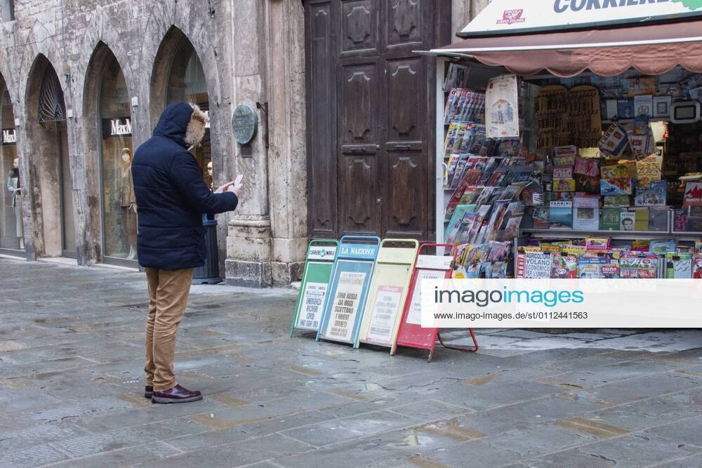 Perugia in the red zone. The capital and the province in full state of emergency covid 19 also due to the variants of the virus present in the area. the city is back in full lockdown. the deserted historic center. anguish and fear reign. one of the two newsstands in the historic center, a gentleman stops to photograph the crocodiles. Editorial Usage Only