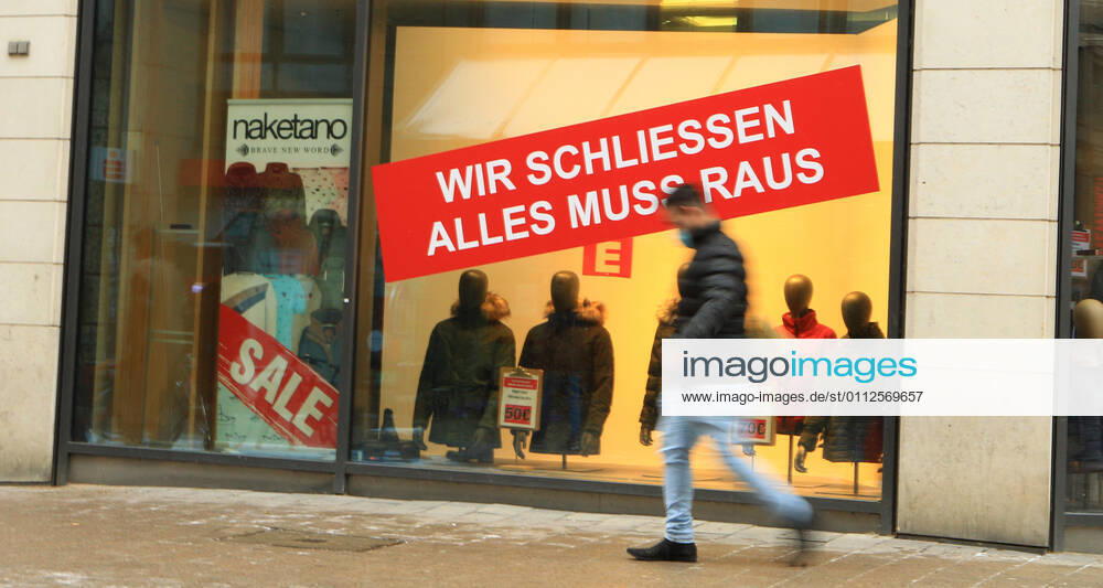 A sticker is stuck in the window of a clothing store closed during the lockdown, indicating that a clearance sale is coming up due to the store closing Downtown Hamburg