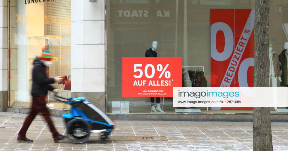 In the window of a retail store closed during the lockdown is a sticker indicating discount promotions Downtown Hamburg