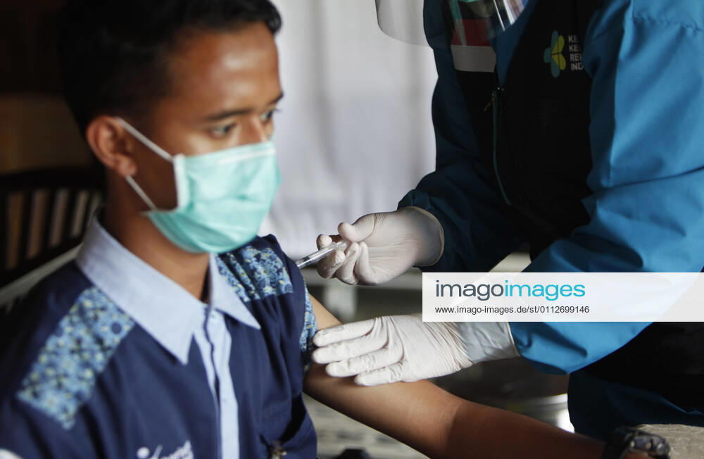 Indonesia s COVID-19 Mass Vaccination A health worker vaccinates her colleague during COVID-19 mass vaccination for medical workers and elderly health workers in Bogor, West Java on February 11, 2021. (Photo by Adrian INA Photo Agency)