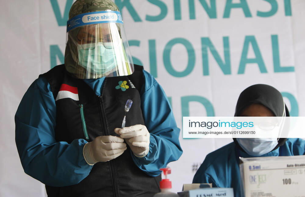 Indonesia s COVID-19 Mass Vaccination A health worker prepares vaccinates her colleague during COVID-19 mass vaccination for medical workers and elderly health workers in Bogor, West Java on February 11, 2021. (Photo by Adrian INA Photo Agency)